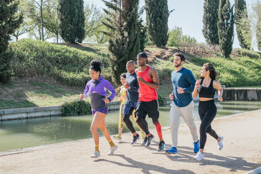 group of runners training in a park. happy and smiling.